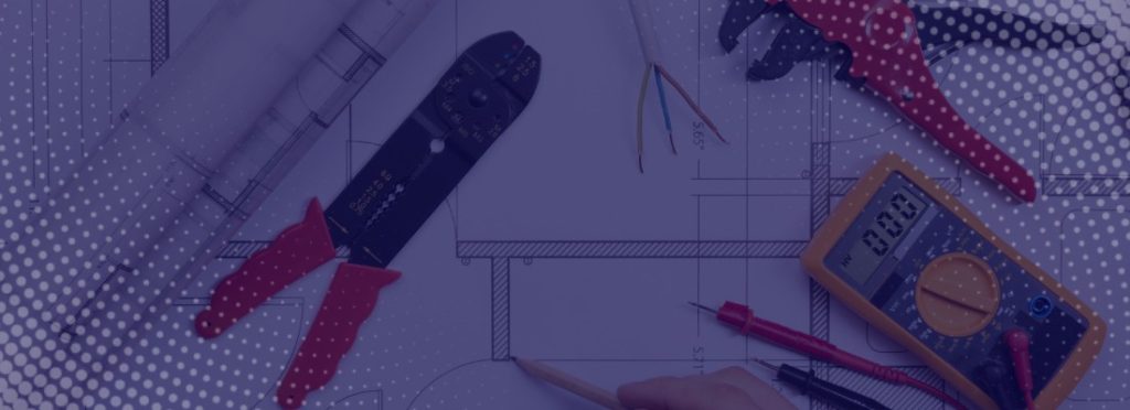 A blueprint surrounded by tools and materials on a work surface.