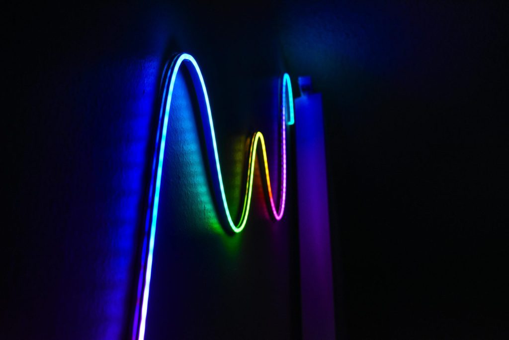 Colorful neon wave pattern LED lights illuminating a dark room for a modern home decor aesthetic.
